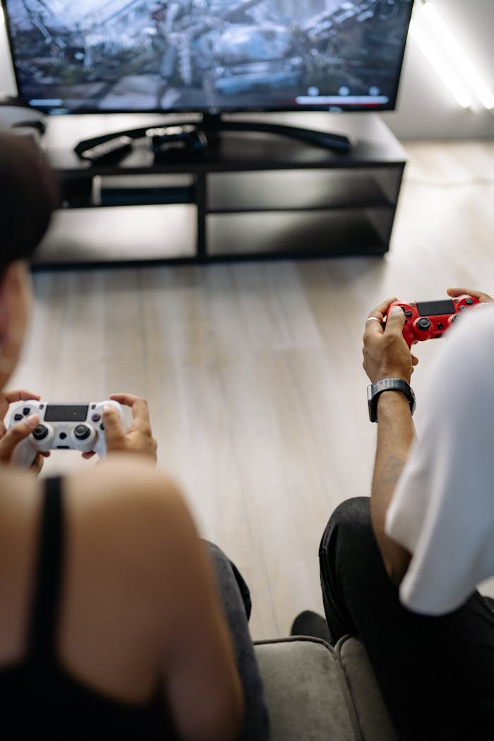 creative-01 Two friends enjoying video games in a comfortable home environment, focused on intense gameplay.
